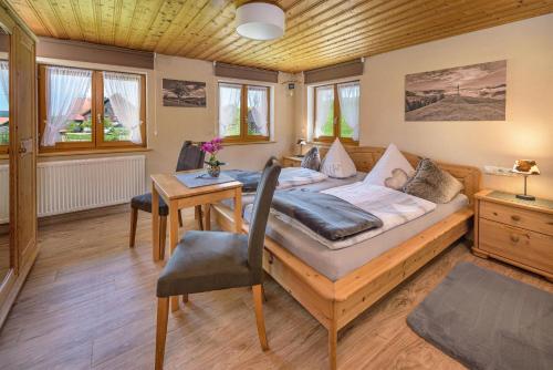 Un dormitorio con una cama y una mesa. en Haus Gorbach, en Oberstaufen
