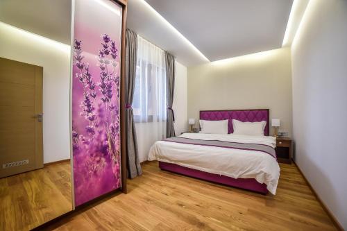 a bedroom with a bed and a purple door at Apartmani Buket Zlatibor in Zlatibor