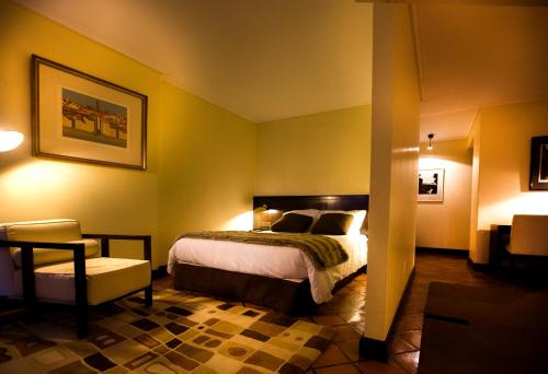 a hotel room with a bed and a chair at Hotel Senhora A Branca in Braga