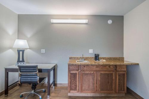 a bathroom with a sink and a desk with a lamp at Quality Inn & Suites Conference Center Thomasville in Thomasville