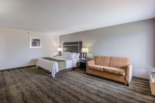 a hotel room with a bed and a chair at Quality Inn & Suites Conference Center Thomasville in Thomasville