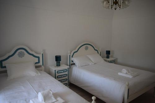 dos camas sentadas una al lado de la otra en un dormitorio en Casa da Avó Maria Ana, en Arraiolos