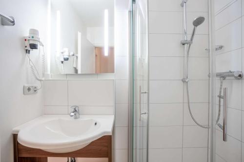 a bathroom with a sink and a shower at Quality Hotel Erlangen Garni in Erlangen