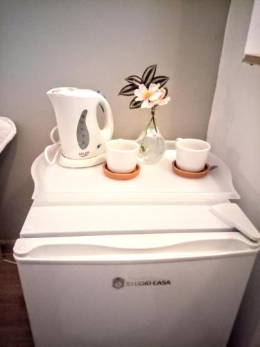 a flower and two cups on top of a toilet at Central Guesthouse in Bucharest