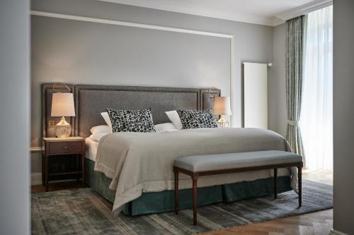 a bedroom with a large bed and a large window at Victoria Jungfrau Grand Hotel & Spa in Interlaken