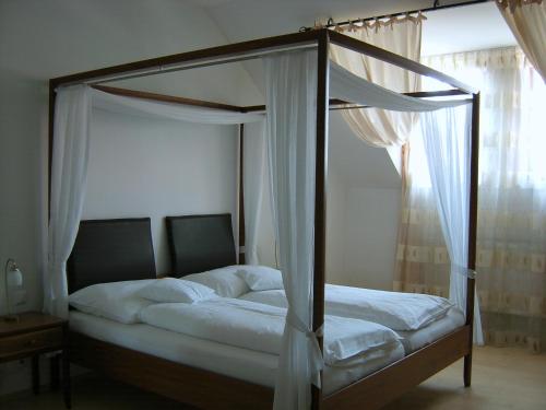 ein Himmelbett in einem Schlafzimmer mit Fenster in der Unterkunft Hanfthal-Hof in Laa an der Thaya