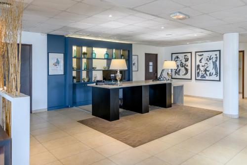 a large desk in a room with blue walls at Comfort Aparthotel Bordeaux Begles Arena in Bègles