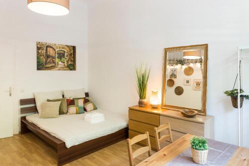 a bedroom with a bed and a table and a mirror at City Center Apartments in Berlin