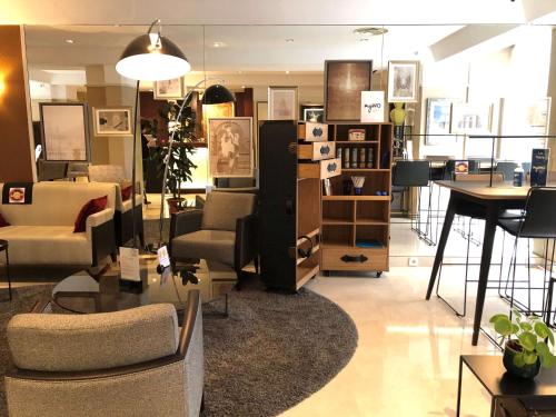 a living room filled with furniture and a table at Best Western Plus Hotel Sydney Opera in Paris