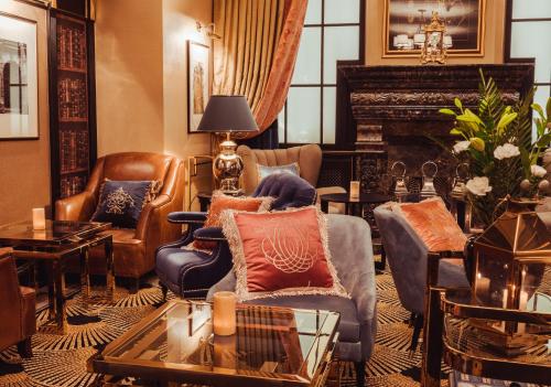 a living room with furniture and a fireplace at Bachleda Luxury Hotel Kraków - MGallery Collection in Kraków