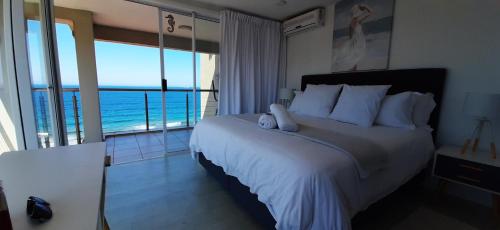 Schlafzimmer mit einem Bett und Meerblick in der Unterkunft 511 Umdloti Resort WOW! Amazing Breakers Views in Umdloti