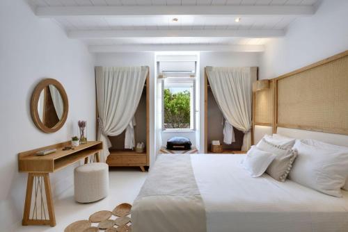 sypialnia z łóżkiem, stołem i lustrem w obiekcie Villa Agia Thalassa Beachfront Luxury Villa Ampelas Paros w mieście Paros