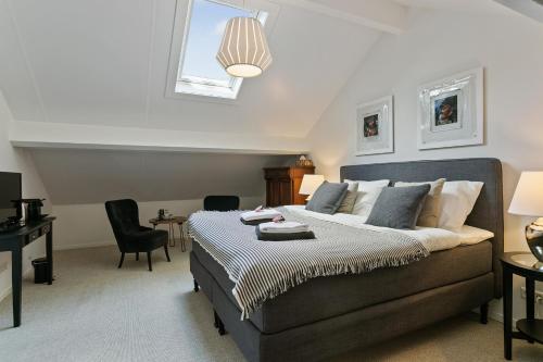 1 dormitorio con 1 cama, mesa y sillas en Bed & Breakfast De Oude Kapel en Driebergen