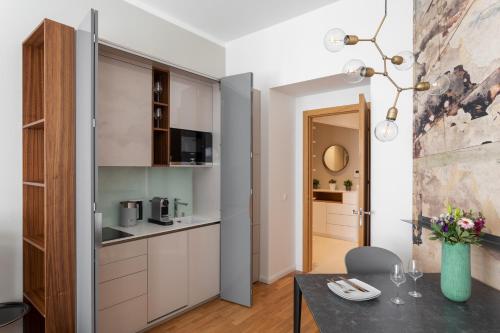 eine Küche mit weißen Schränken und einem Esstisch in der Unterkunft Elegant Studios near Wenceslas Square by Prague Days in Prag