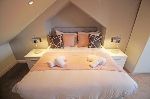 a bedroom with a large bed with two towels on it at Queens Road - Luxury Spacious Home in Chester in Christleton