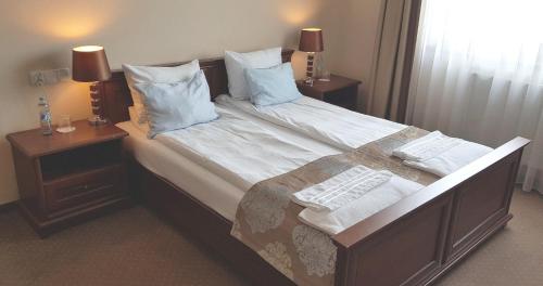 a bedroom with a large bed with white sheets and pillows at Confero Nowa Baśń in Nysa