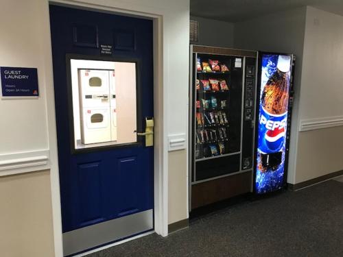 a vending machine next to a blue door and a refrigerator at InTown Suites Extended Stay Chicago IL - Oakbrook in Villa Park