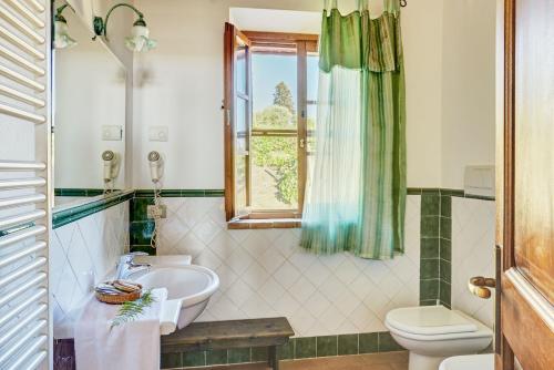 a bathroom with a sink and a toilet and a window at Podere Lamino in Monticchiello
