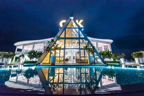 a building with a reflection in the water at night at Genting Premium Suite Windmill Upon Hills by JAz Home Suites in Genting Highlands