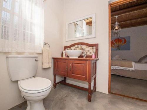 une salle de bain avec des toilettes blanches et un lavabo dans l'établissement New Beginnings Cottage, à Montagu