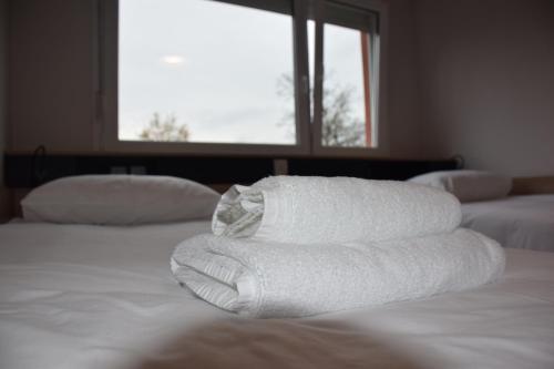 a stack of towels sitting on top of a bed at Accommodation Vitalis in Ljubljana