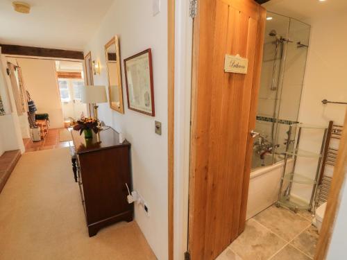 a bathroom with a shower and a glass door at Crosscombe Barn in Kingsbridge