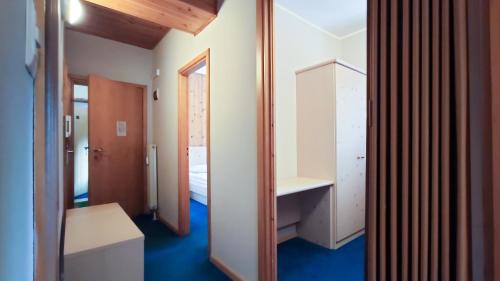Habitación pequeña con cama y espejo. en Hotel Principe Marmolada en Malga Ciapela