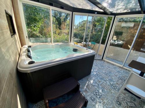 a large bath tub in a room with windows at suite phantastica in Les-Pennes-Mirabeau