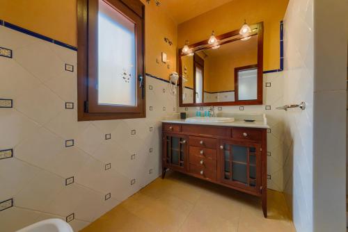 a bathroom with a sink and a mirror at Holidays2Malaga Candado House pool & garden in Málaga