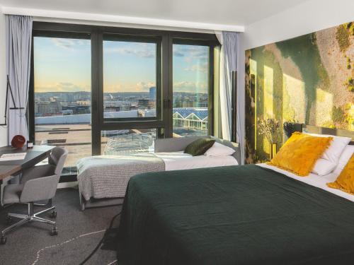 a hotel room with two beds and a large window at Novotel Paris Porte Versailles in Paris