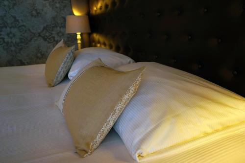 a bed with two pillows and a lamp on it at Abdij Hotel Rolduc in Kerkrade