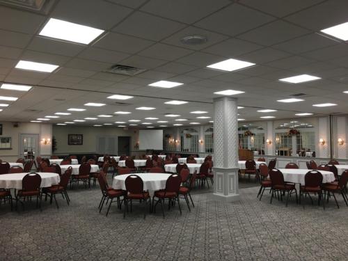 a banquet hall with white tables and red chairs at 1863 Inn of Gettysburg in Gettysburg