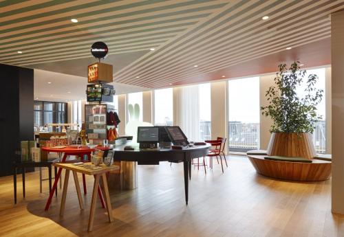 een lobby met een tafel en stoelen in een gebouw bij citizenM Copenhagen Radhuspladsen in Kopenhagen