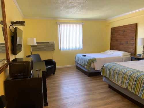 a hotel room with two beds and a television at Lake Inn in Ebensburg