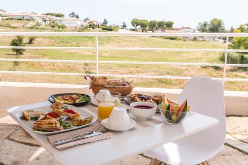 a tray of breakfast food on a table on a balcony at Camere Relais Filomare in Marcelli