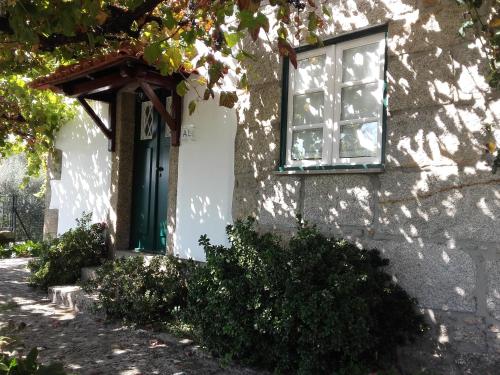 a house with a green door and a window at Cottage - Vitorino dos Piães in Vitorino dos Piães