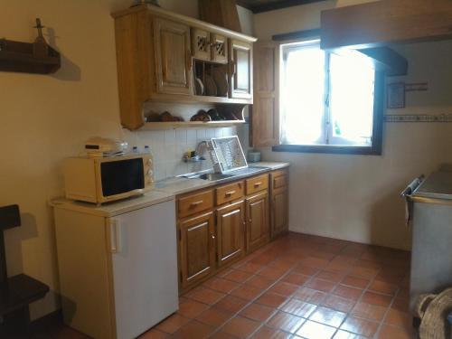 a small kitchen with a microwave and a sink at Cottage - Vitorino dos Piães in Vitorino dos Piães