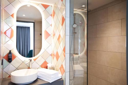 uma casa de banho com um lavatório e um chuveiro em ibis Styles Klagenfurt am Woerthersee em Klagenfurt