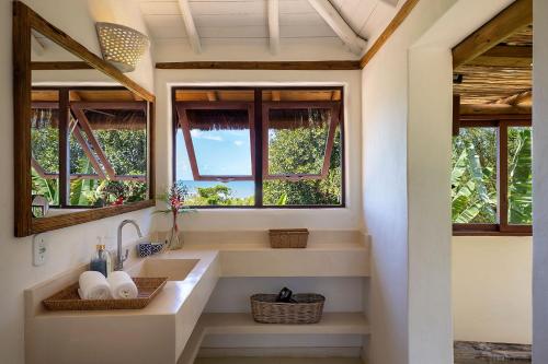 baño con lavabo y 2 ventanas en Casas da Lia, en Trancoso
