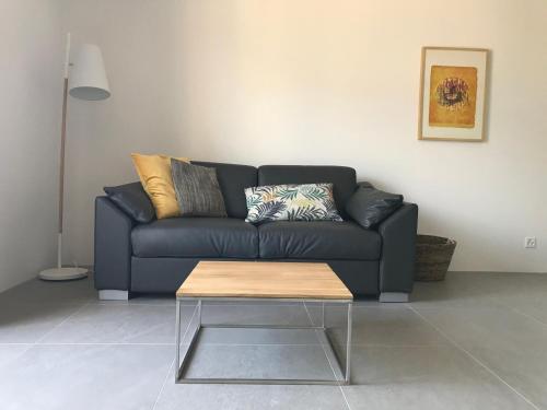 Sala de estar con sofá negro y mesa de centro en Muralto-Locarno: Miramonti Apt. 17 en Locarno