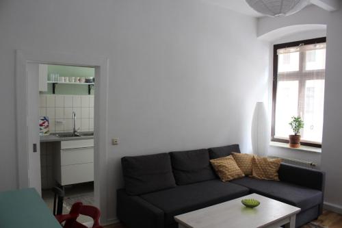 a living room with a black couch and a table at Gemütliche Ferienwohnung in Görlitz in Görlitz