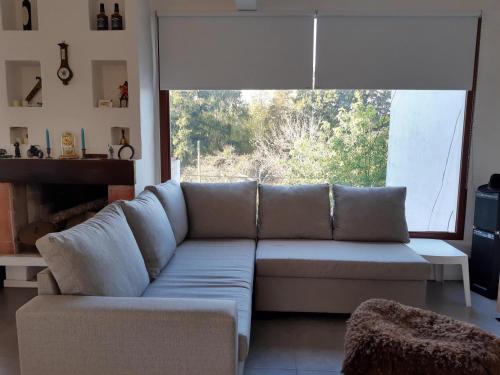 a living room with a couch and a large window at Duplex Rio Lujan CUBE in Belén de Escobar