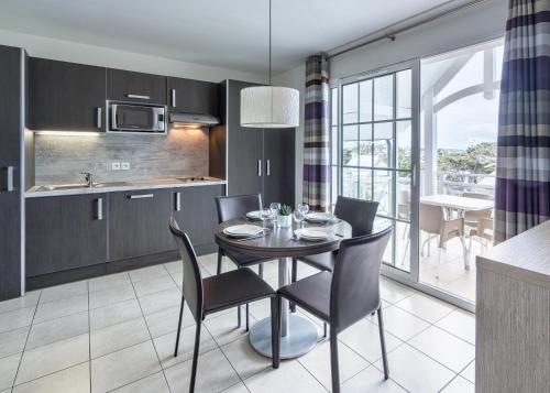a kitchen and dining room with a table and chairs at Les Villas du SPA in Pléneuf-Val-André
