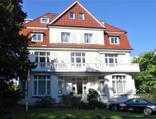 a white house with a red roof at Apartments Villa Seeblick Travemünde in Travemünde