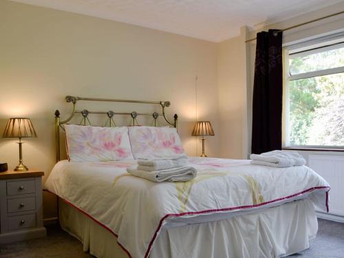 a bedroom with a bed with towels on it at Tan y Gaer in Aberystwyth