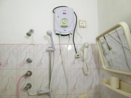 a bathroom with a shower with a phone on the wall at Hotel Surasa in Kurunegala