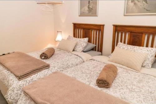 duas camas sentadas uma ao lado da outra num quarto em New Beginnings Cottage em Montagu