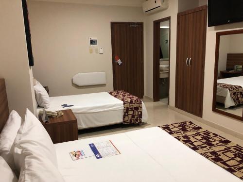 a hotel room with two beds and a mirror at Howard Johnson by Wyndham Barranquilla Versalles in Barranquilla