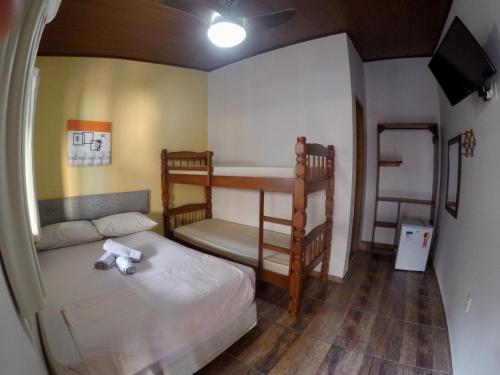 a bedroom with two bunk beds and a tv at Ilha Grande Mar in Abraão