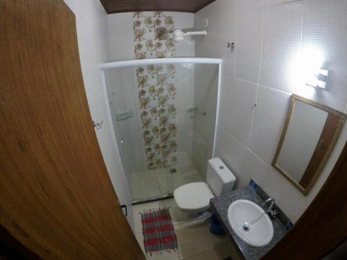 uma casa de banho com um chuveiro, um WC e um lavatório. em Ilha Grande Mar em Abraão
